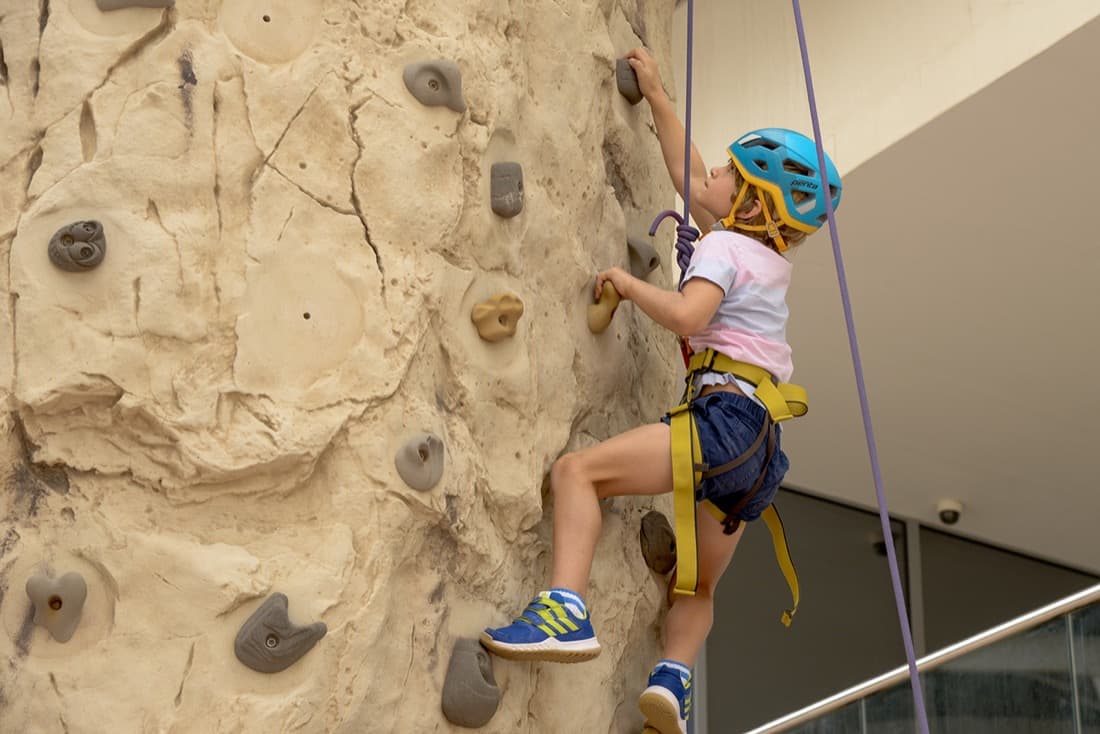 A child climbing an indoor wall at holiday camp